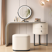 Modular lighted round mirror vanity with glowing LED ring, dual drawers, fabric-lined storage cabinet, and padded stool in elegant tones.