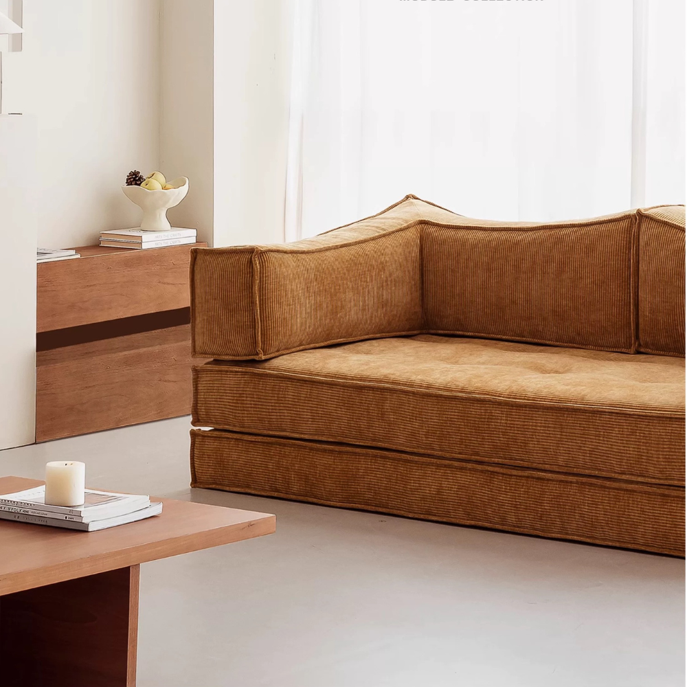 Compressed modular sofa bed in brown corduroy or yellow linen – deep seat, convertible, space-saving, eco-friendly fabric, texture close-up, 2025 trend.